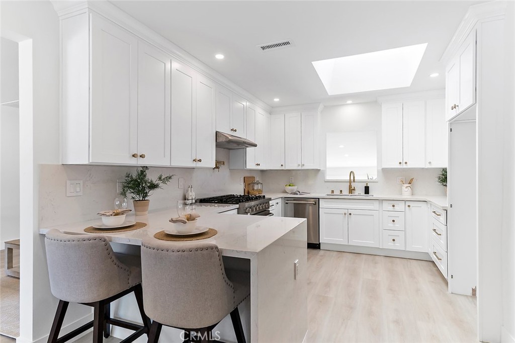 732 East Foothill Boulevard Glendora, CA 91741 - Photo 10 of 61 a kitchen with a stove a sink a dining table and chairs