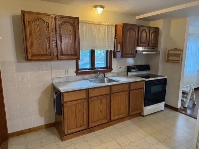 a kitchen with stainless steel appliances granite countertop a sink stove and cabinets