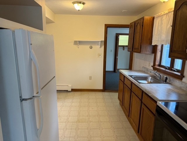 294 Pond Street, Unit 1 Braintree, MA 02184 - Photo 4 of 15 a kitchen with granite countertop a refrigerator and a sink