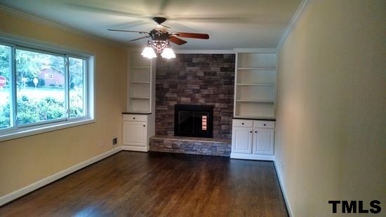 4408 Greenbrier Road Raleigh, NC 27603 - Photo 2 of 9 a living room with hard wood floors and a fireplace
