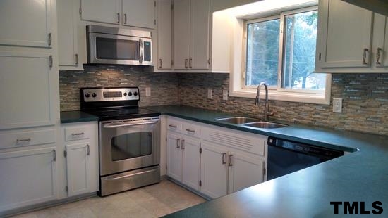 4408 Greenbrier Road Raleigh, NC 27603 - Photo 4 of 9 a kitchen with stainless steel appliances granite countertop a sink a stove and microwave