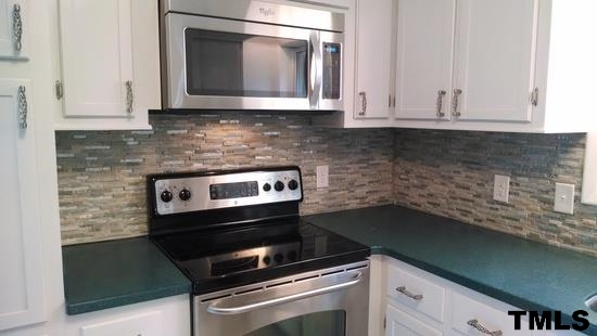 4408 Greenbrier Road Raleigh, NC 27603 - Photo 5 of 9 a kitchen with granite countertop white cabinets and appliances