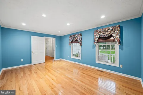 a view of an empty room with a window and a ceiling fan