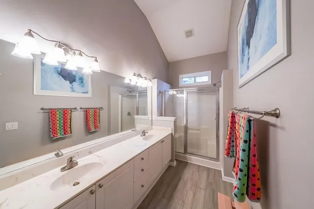 a bathroom with a double vanity sink mirror and shower