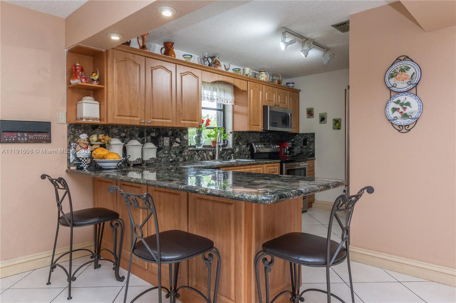 13560 Southwest 2nd Street Miami, FL 33184 - Photo 13 of 50 a kitchen with stainless steel appliances granite countertop a sink and a refrigerator