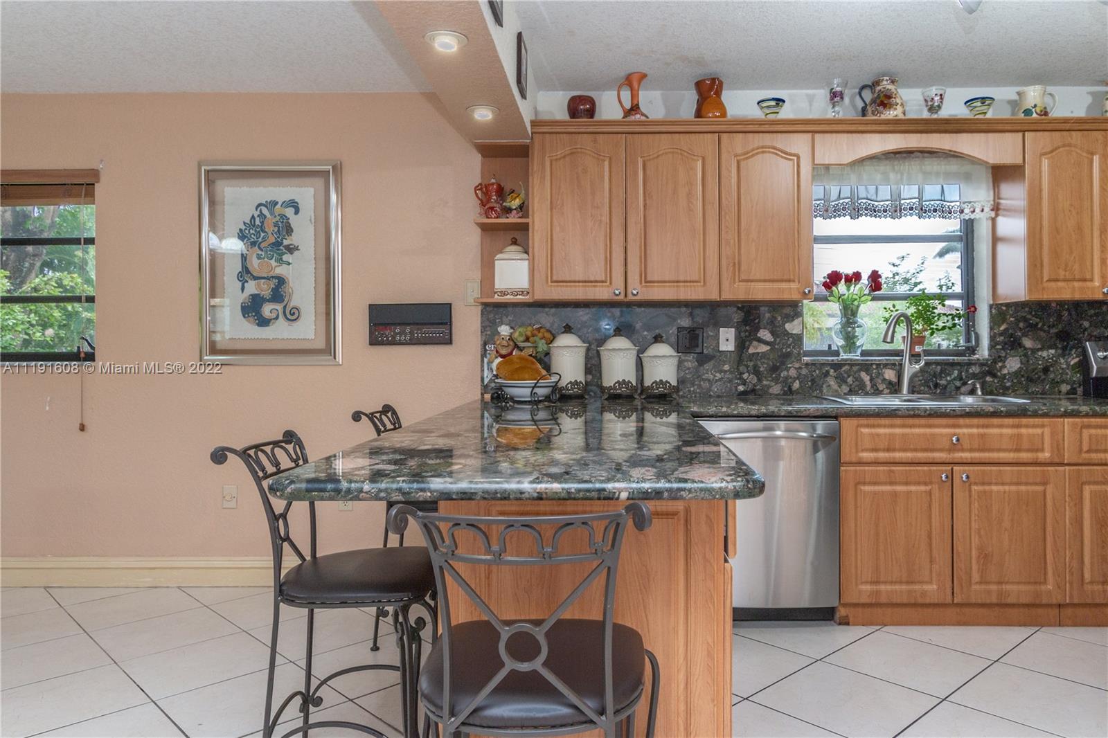 13560 Southwest 2nd Street Miami, FL 33184 - Photo 15 of 50 a kitchen with stainless steel appliances granite countertop a sink and cabinets