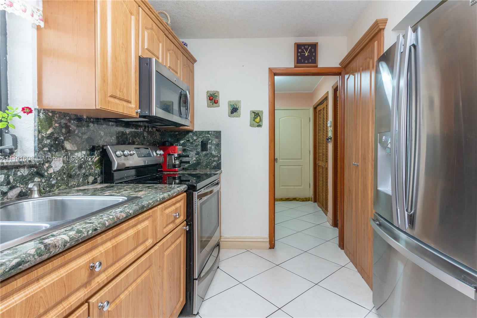 13560 Southwest 2nd Street Miami, FL 33184 - Photo 16 of 50 a kitchen with granite countertop stainless steel appliances a refrigerator and a sink