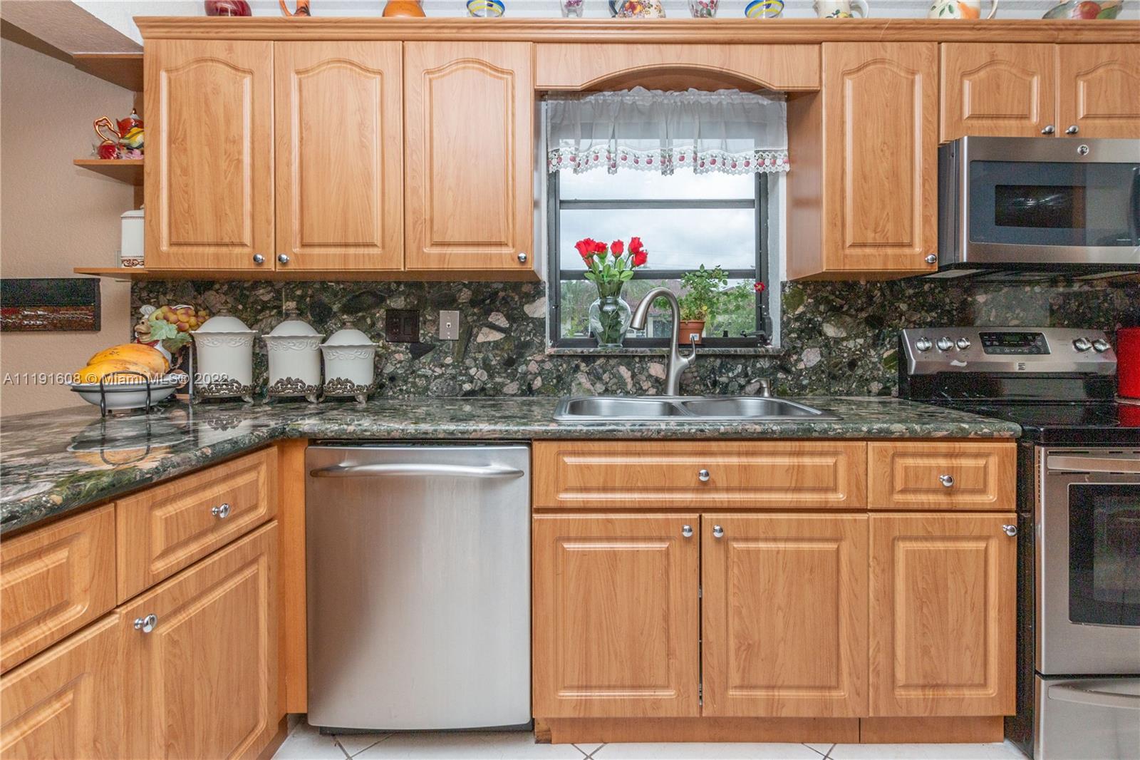 13560 Southwest 2nd Street Miami, FL 33184 - Photo 17 of 50 a kitchen with stainless steel appliances granite countertop a stove a sink and a microwave