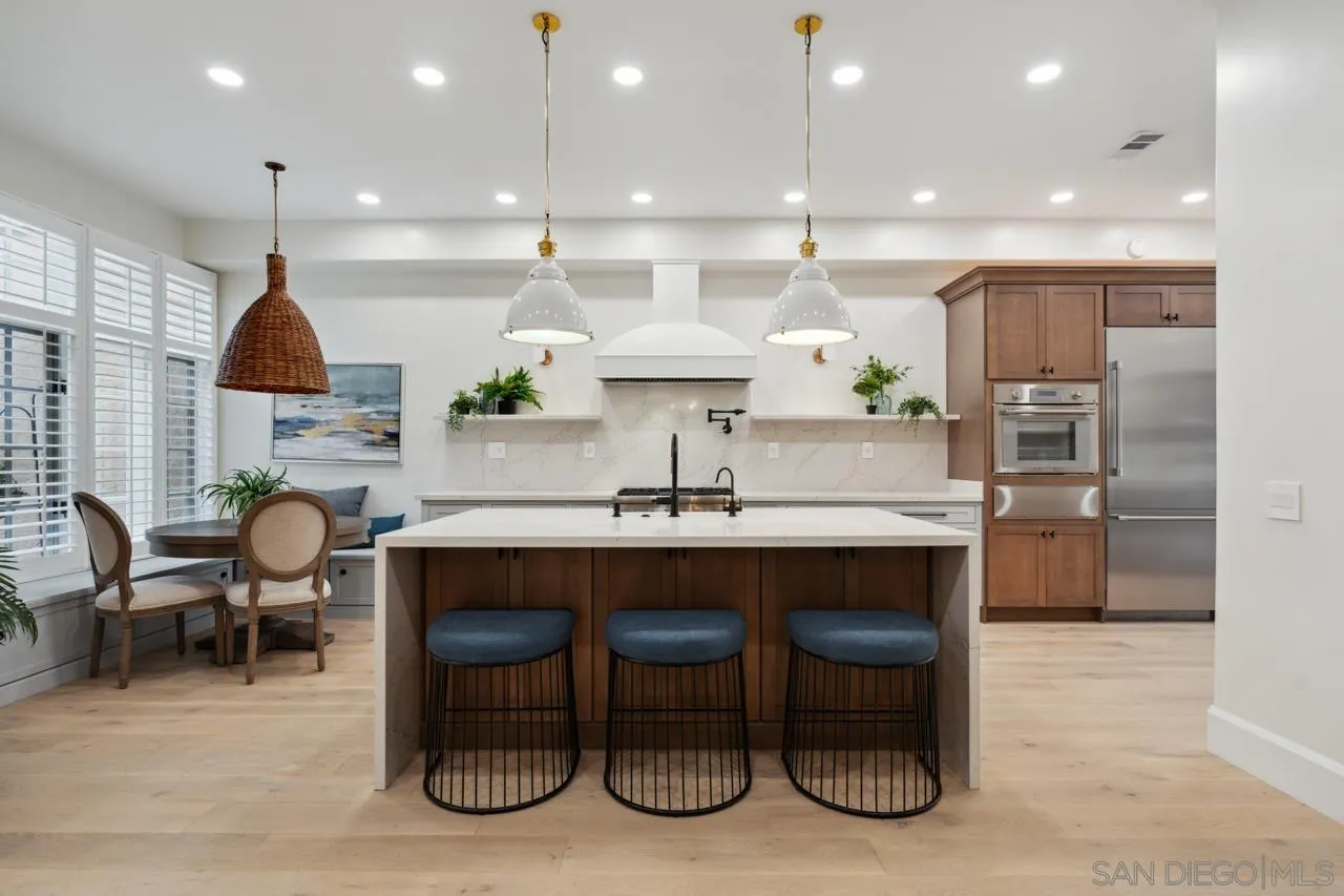 15345 Via Simpatico Rancho Santa Fe, CA 92091 - Photo 8 of 75 a kitchen with stainless steel appliances a dining table chairs sink and cabinets