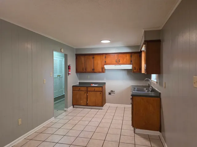 a kitchen with granite countertop a refrigerator and a stove top oven