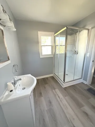 a bathroom with a sink and mirror with bathtub