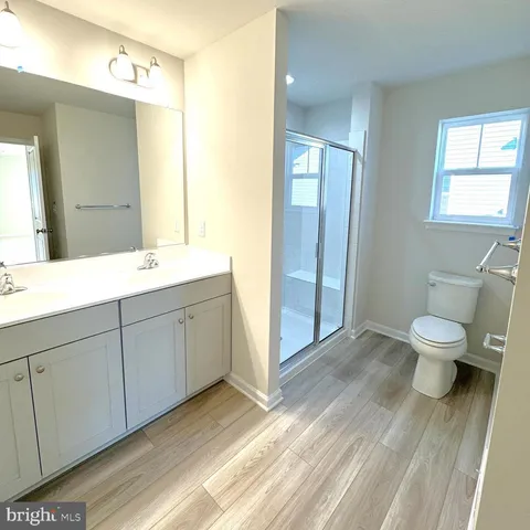 a spacious bathroom with a double vanity sink toilet and a mirror