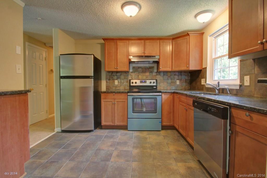 6625 Reddman Road Charlotte, NC 28212 - Photo 2 of 24 a kitchen with a sink a refrigerator and cabinets