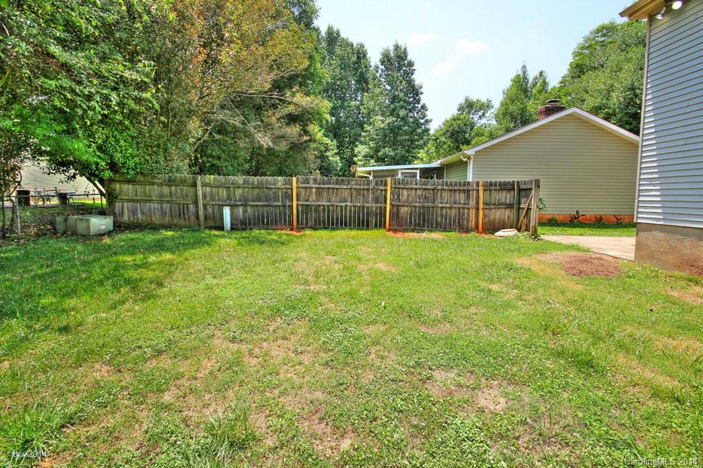 6625 Reddman Road Charlotte, NC 28212 - Photo 19 of 24 a swimming pool with wooden fence and trees in the background