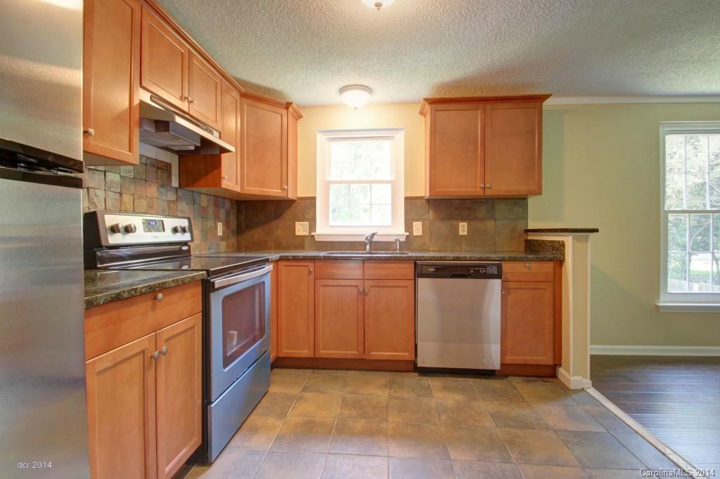 6625 Reddman Road Charlotte, NC 28212 - Photo 3 of 24 a kitchen with stainless steel appliances granite countertop a stove a sink and a refrigerator