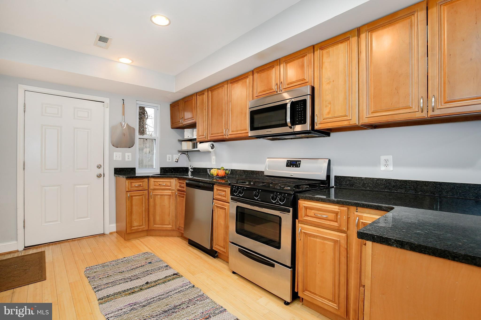 714 19th Street Northeast Washington, DC 20002 - Photo 14 of 27 a kitchen with stainless steel appliances granite countertop a stove a sink and a microwave
