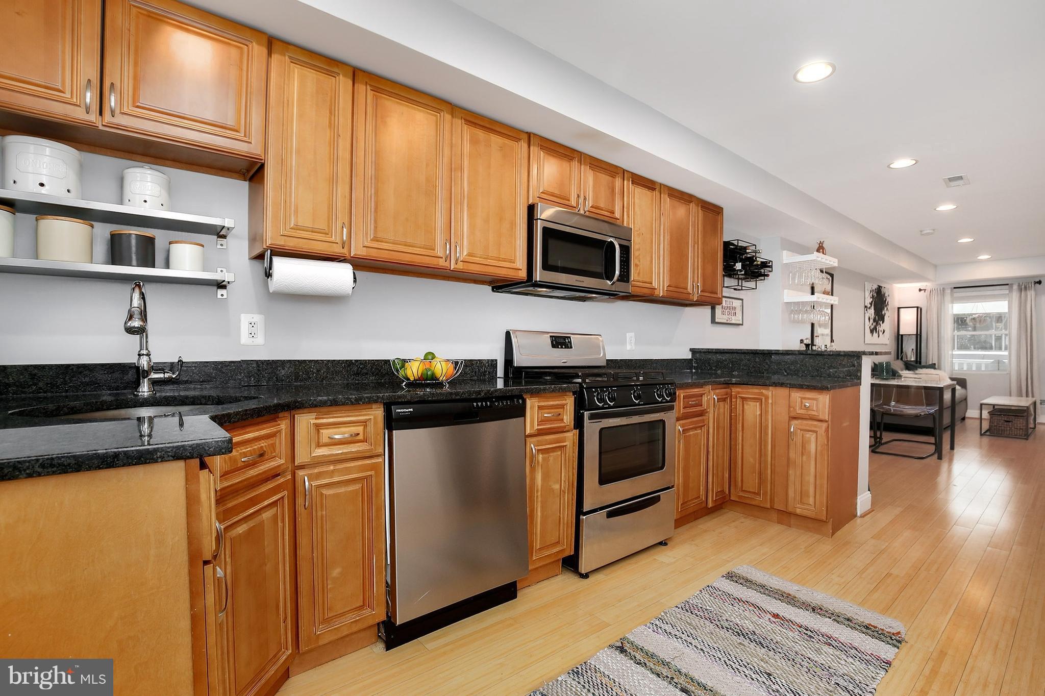 714 19th Street Northeast Washington, DC 20002 - Photo 15 of 27 a kitchen with stainless steel appliances granite countertop a stove top oven a sink dishwasher and cabinets with wooden floor