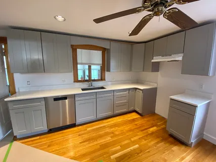 a kitchen with a sink cabinets and wooden floor