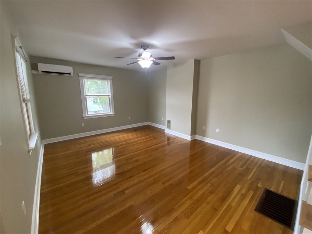 22 Harkins Street, Unit L Quincy, MA 02169 - Photo 5 of 15 a view of empty room with wooden floor and fan