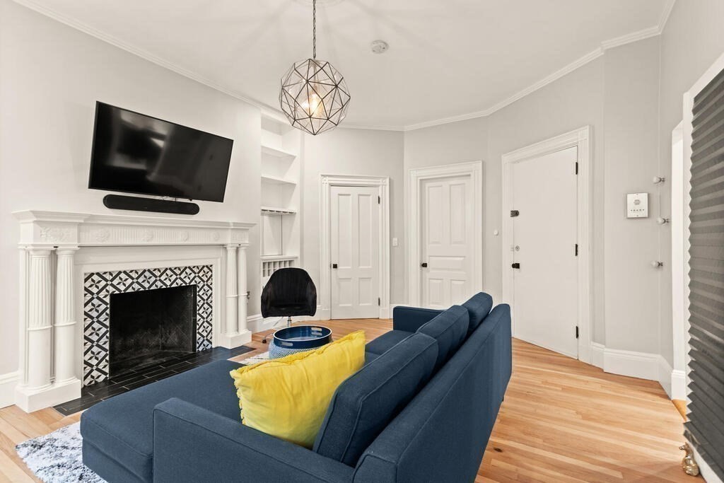 473 Beacon Street, Unit 5 Boston, MA 02115 - Photo 3 of 21 a living room with furniture a flat screen tv and a fireplace