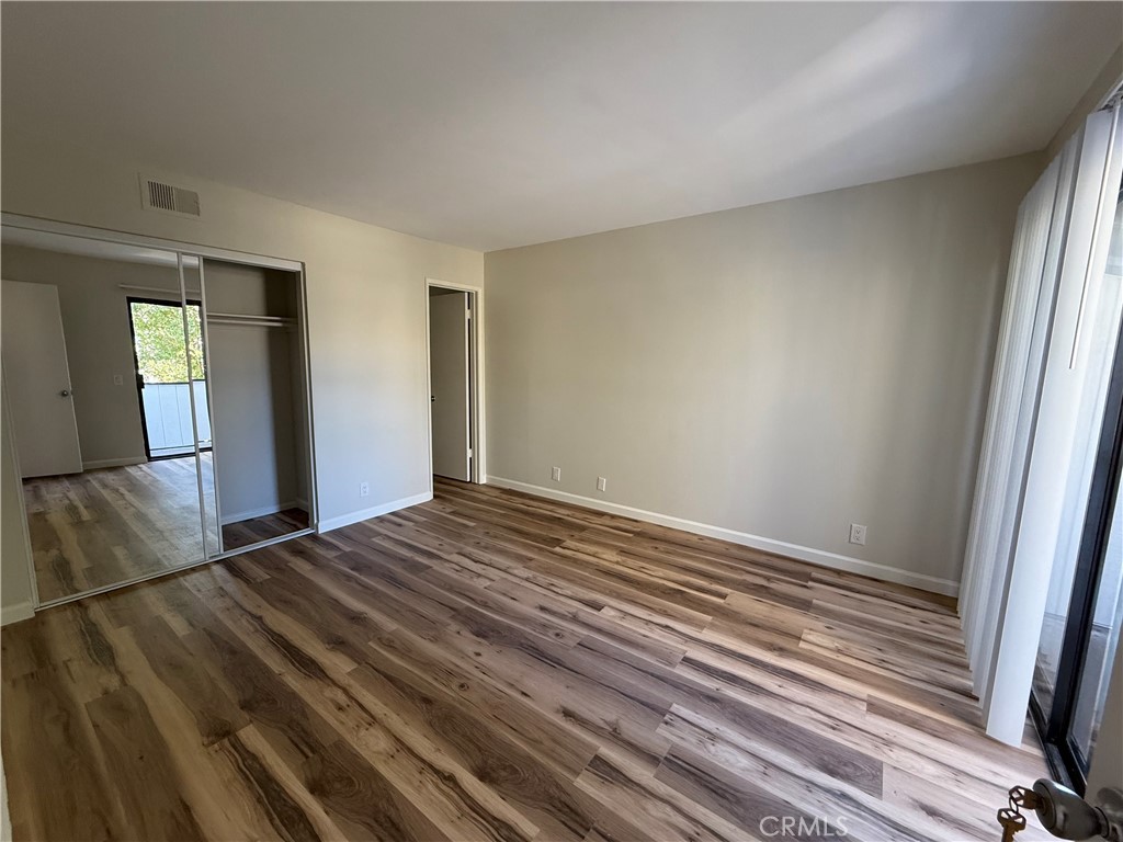 5250 Colodny Drive, Unit 21 Agoura Hills, CA 91301 - Photo 12 of 14 an empty room with wooden floor and windows