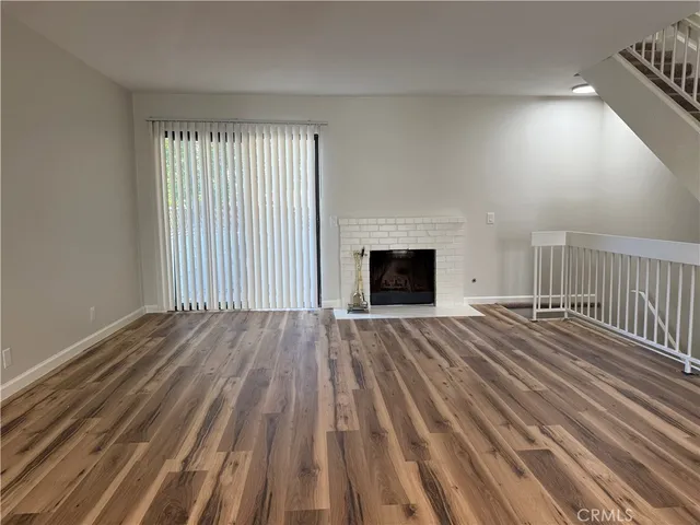 wooden floor fireplace and natural light in room