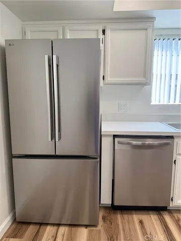 a utility room with wooden floor washer and dryer