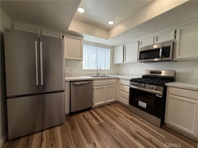 a kitchen with stainless steel appliances a refrigerator sink and microwave