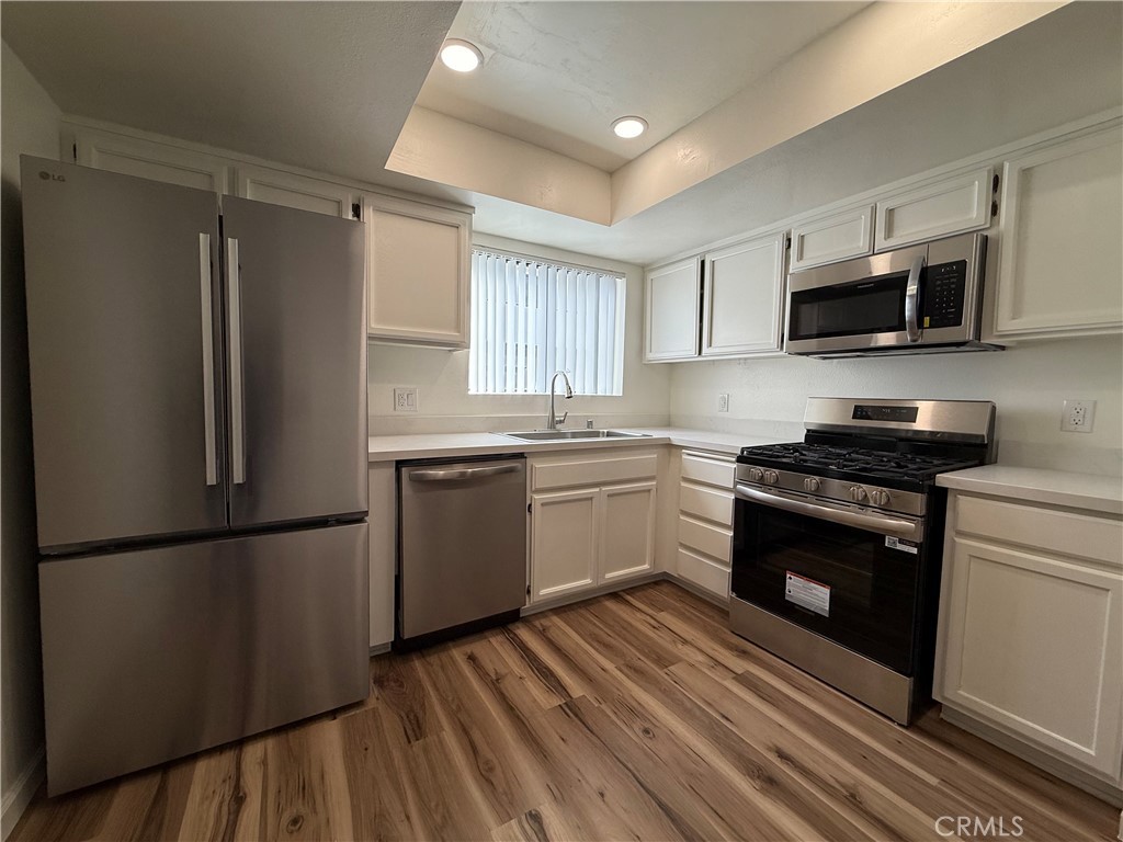 5250 Colodny Drive, Unit 21 Agoura Hills, CA 91301 - Photo 6 of 14 a kitchen with stainless steel appliances a refrigerator sink and microwave