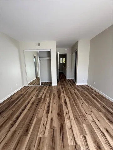 a view of a bedroom with wooden floor and bedroom