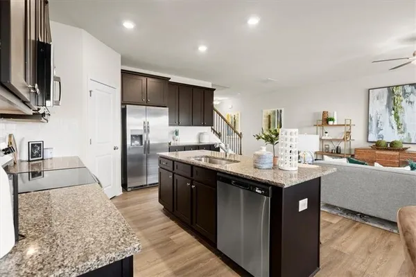 a kitchen with stainless steel appliances granite countertop a sink stove and refrigerator