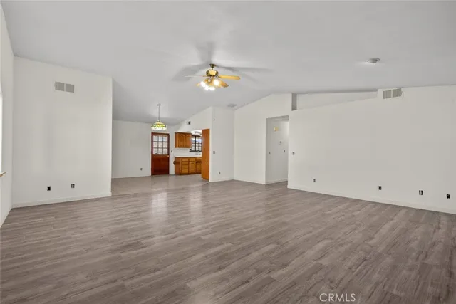 an empty room with wooden floor and natural light