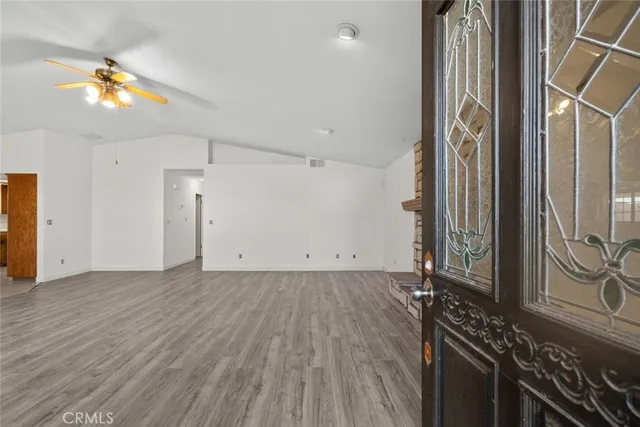 a view of a room with wooden floor and a ceiling fan