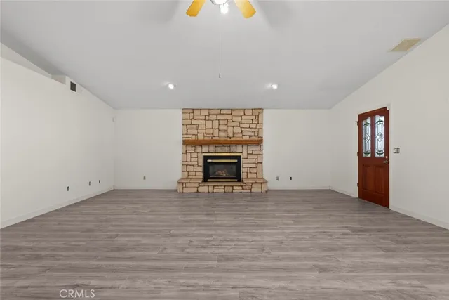 a view of an empty room with a fireplace and a window
