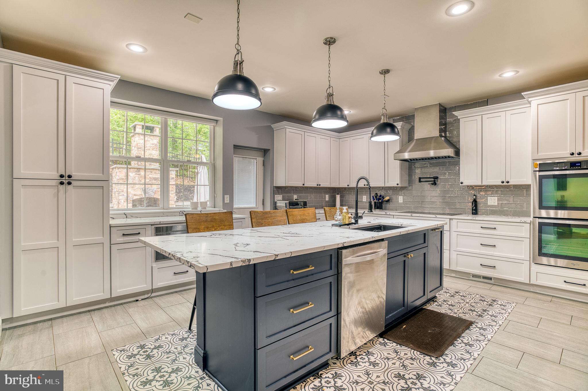 7140 Barry Road Alexandria, VA 22315 - Photo 16 of 56 a kitchen with a stove a sink a center island a stove and a window