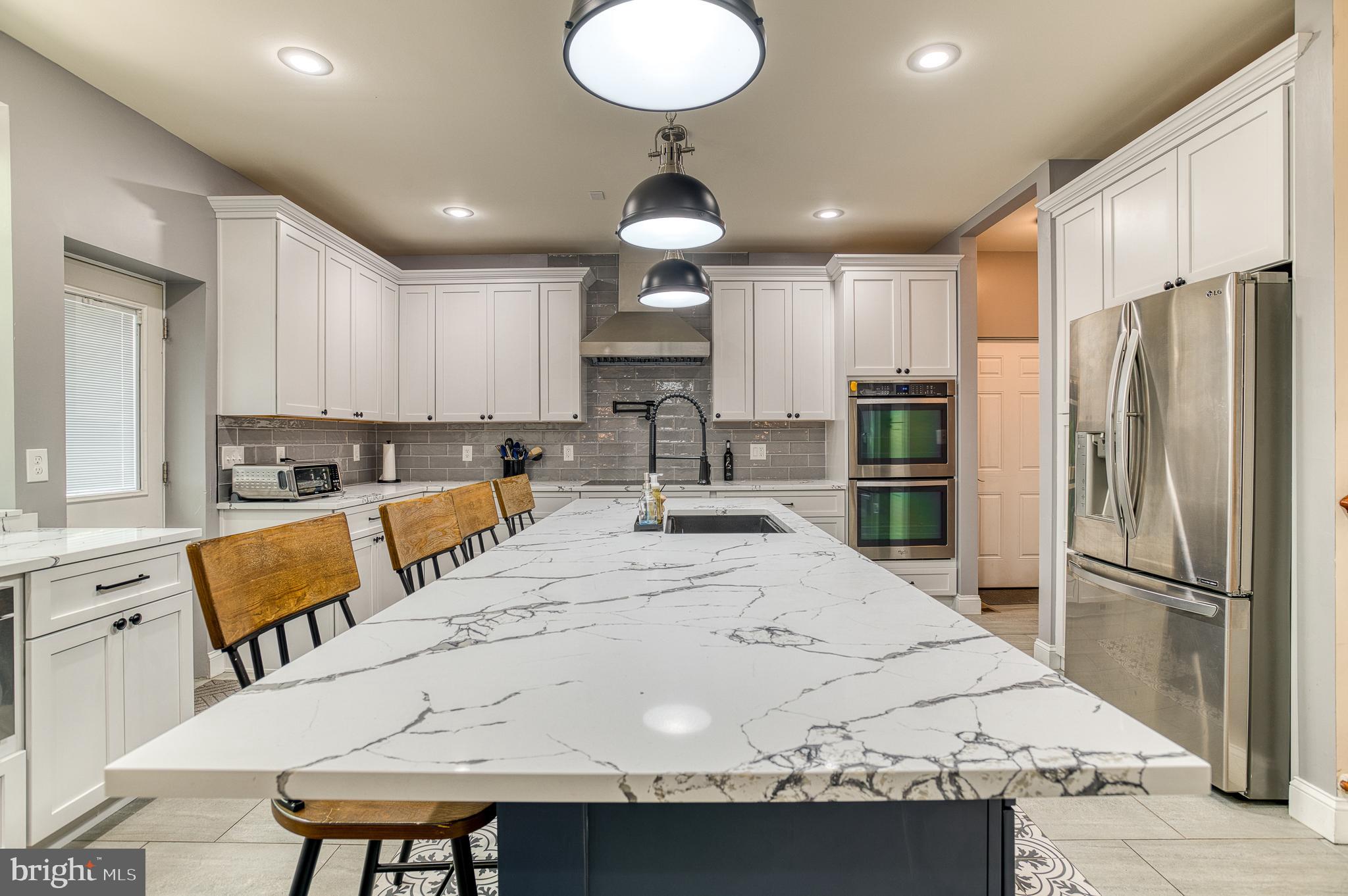 7140 Barry Road Alexandria, VA 22315 - Photo 19 of 56 a kitchen with stainless steel appliances kitchen island granite countertop a sink a stove a refrigerator cabinets and a dining table