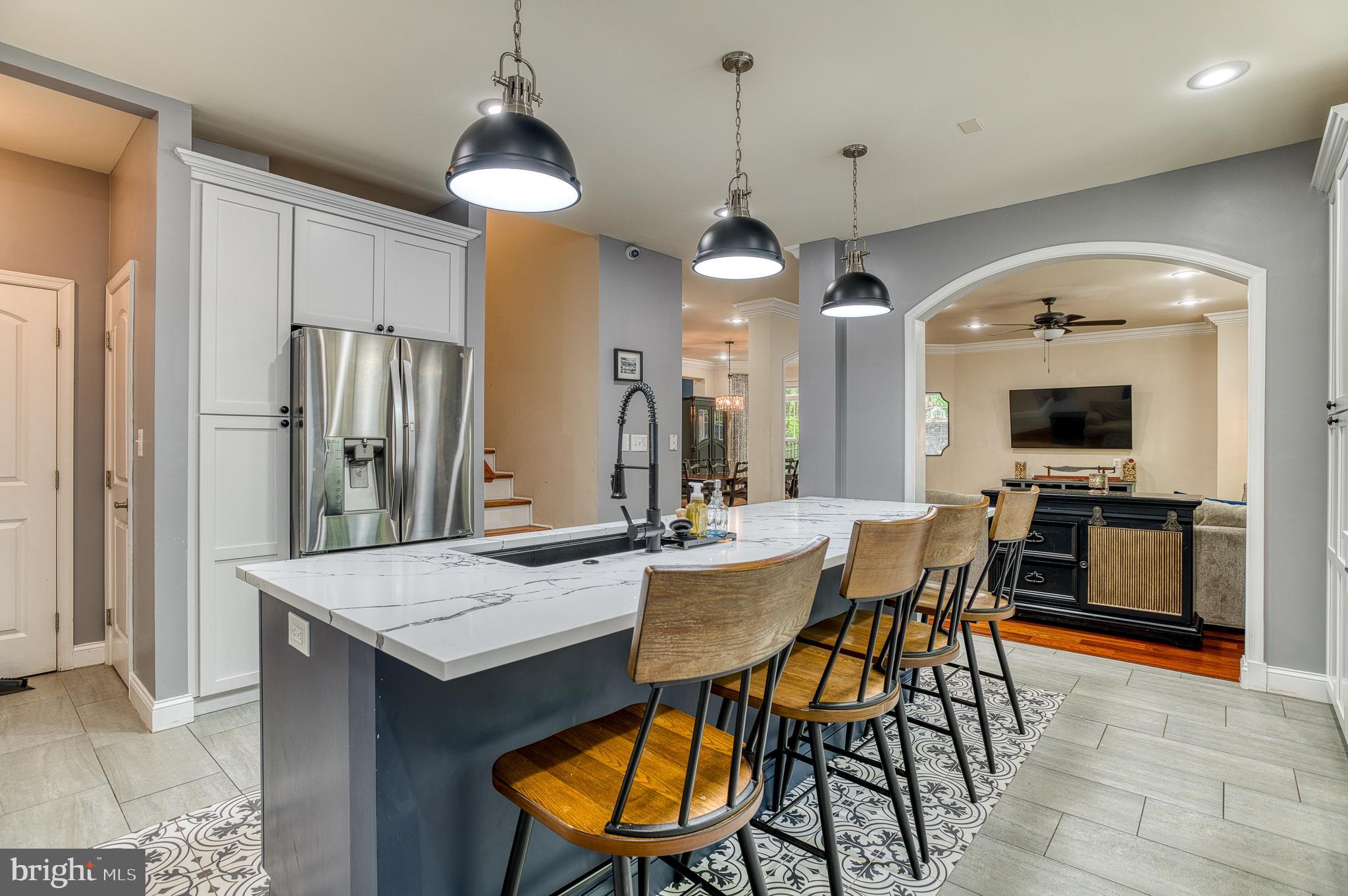 7140 Barry Road Alexandria, VA 22315 - Photo 20 of 56 a kitchen with stainless steel appliances kitchen island granite countertop a table chairs and a refrigerator