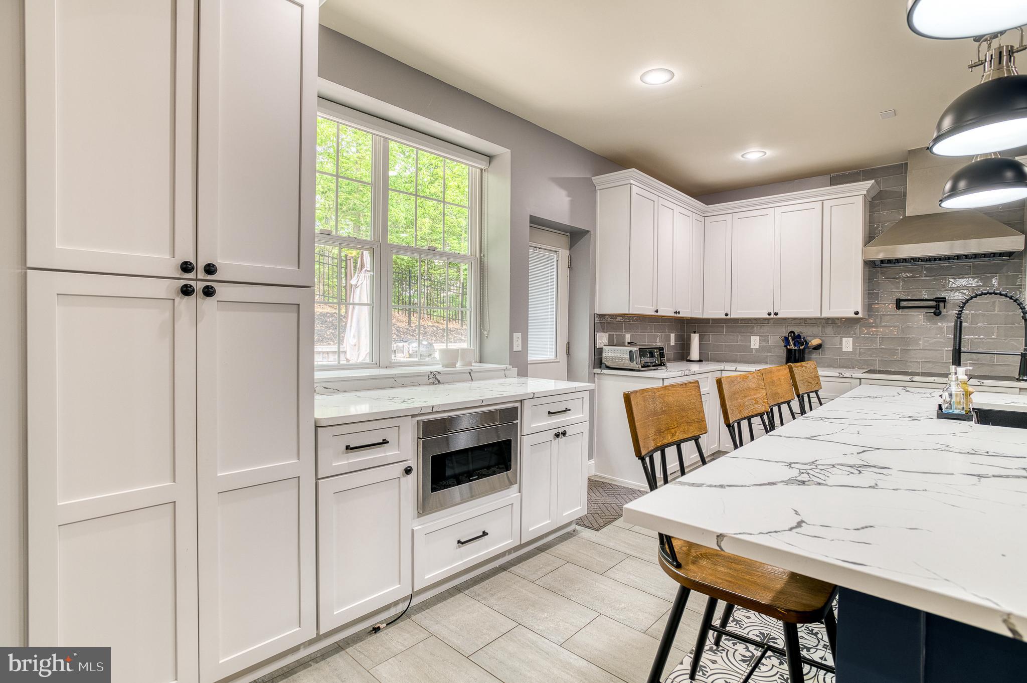 7140 Barry Road Alexandria, VA 22315 - Photo 21 of 56 a kitchen with white cabinets and white appliances