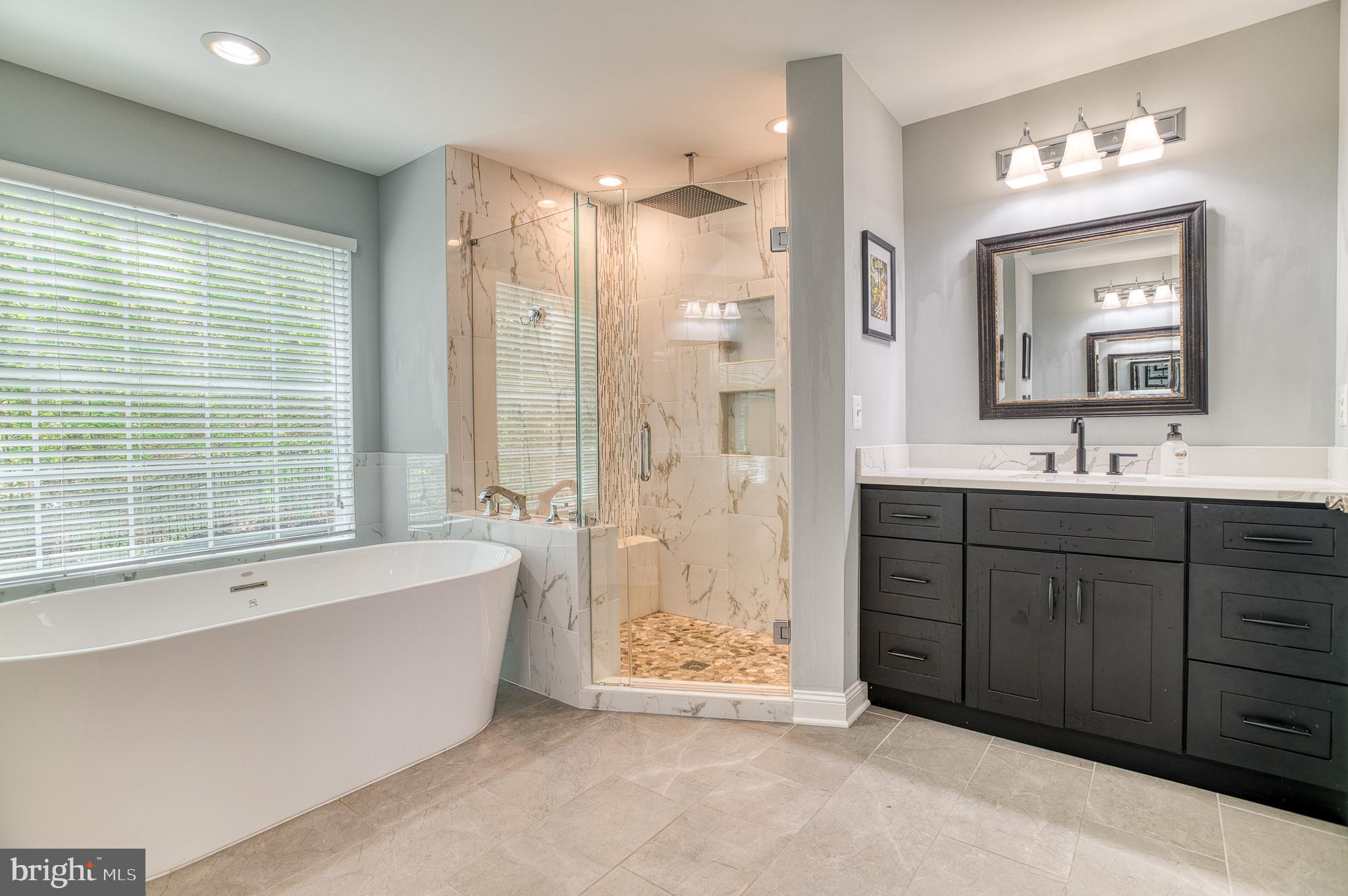 7140 Barry Road Alexandria, VA 22315 - Photo 26 of 56 a spacious bathroom with a tub sink shower and mirror