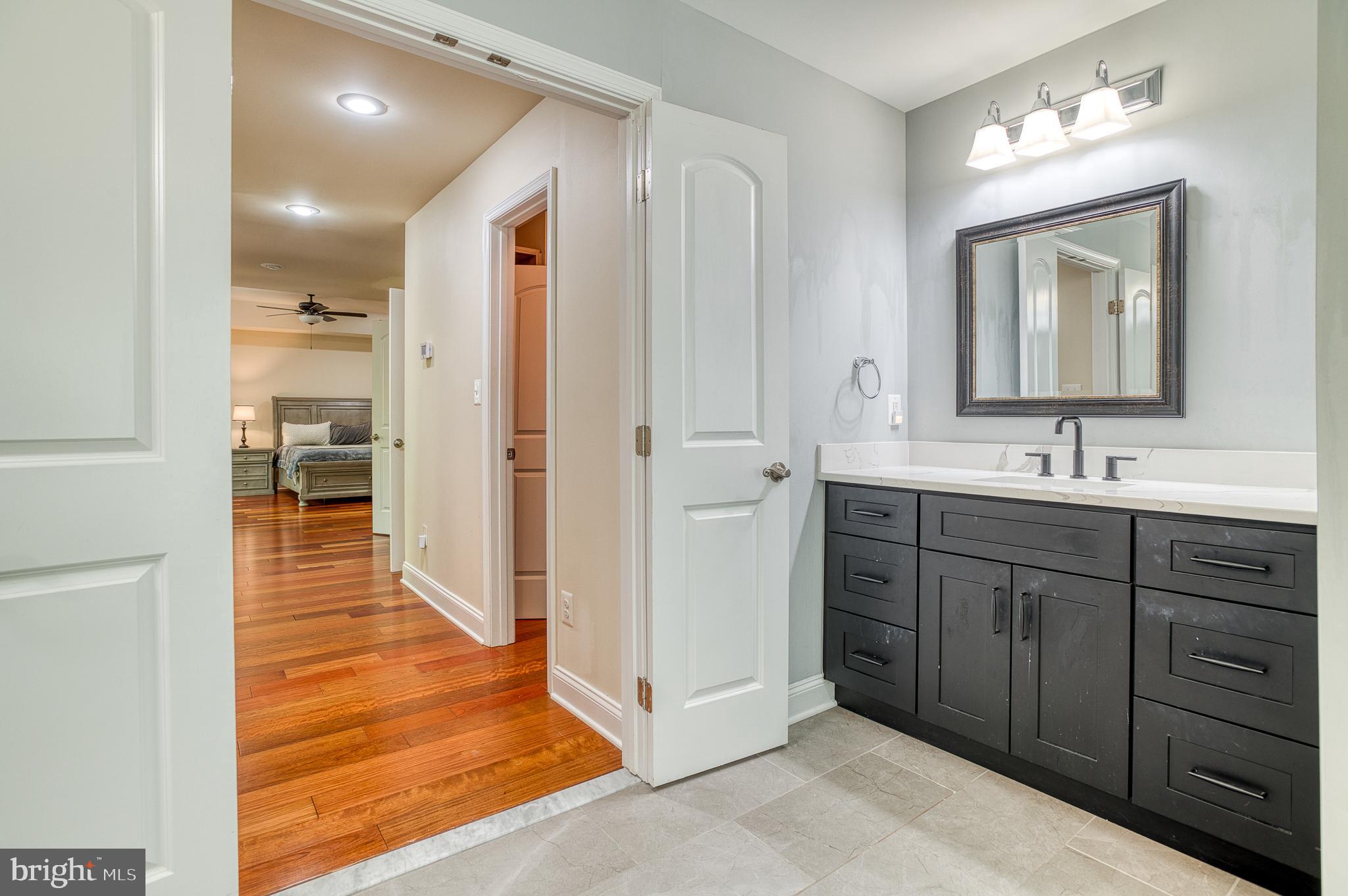 7140 Barry Road Alexandria, VA 22315 - Photo 27 of 56 a spacious bathroom with a vanity a sink a mirror and a shower