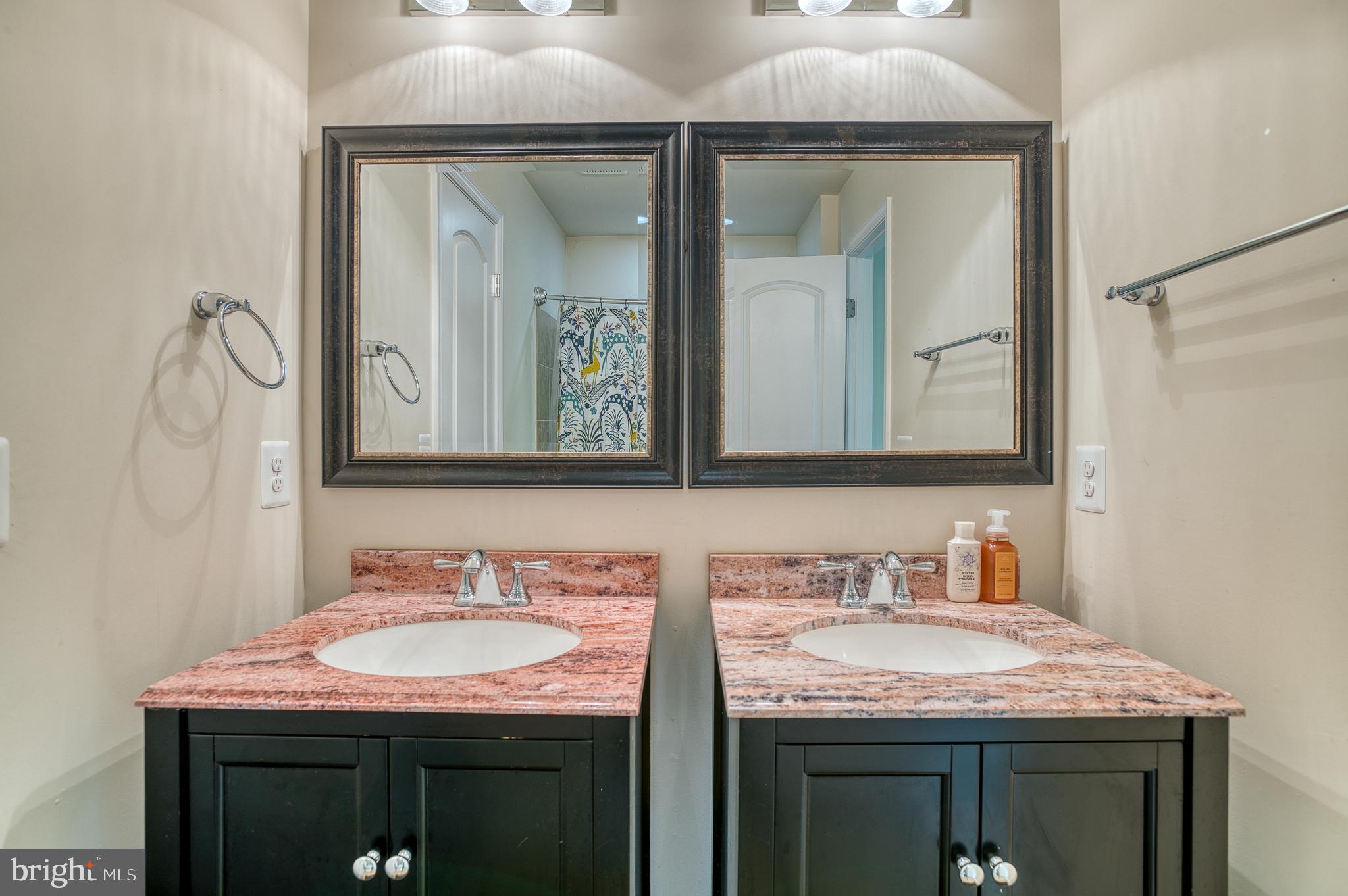 7140 Barry Road Alexandria, VA 22315 - Photo 32 of 56 a bathroom with a granite countertop sink and a mirror