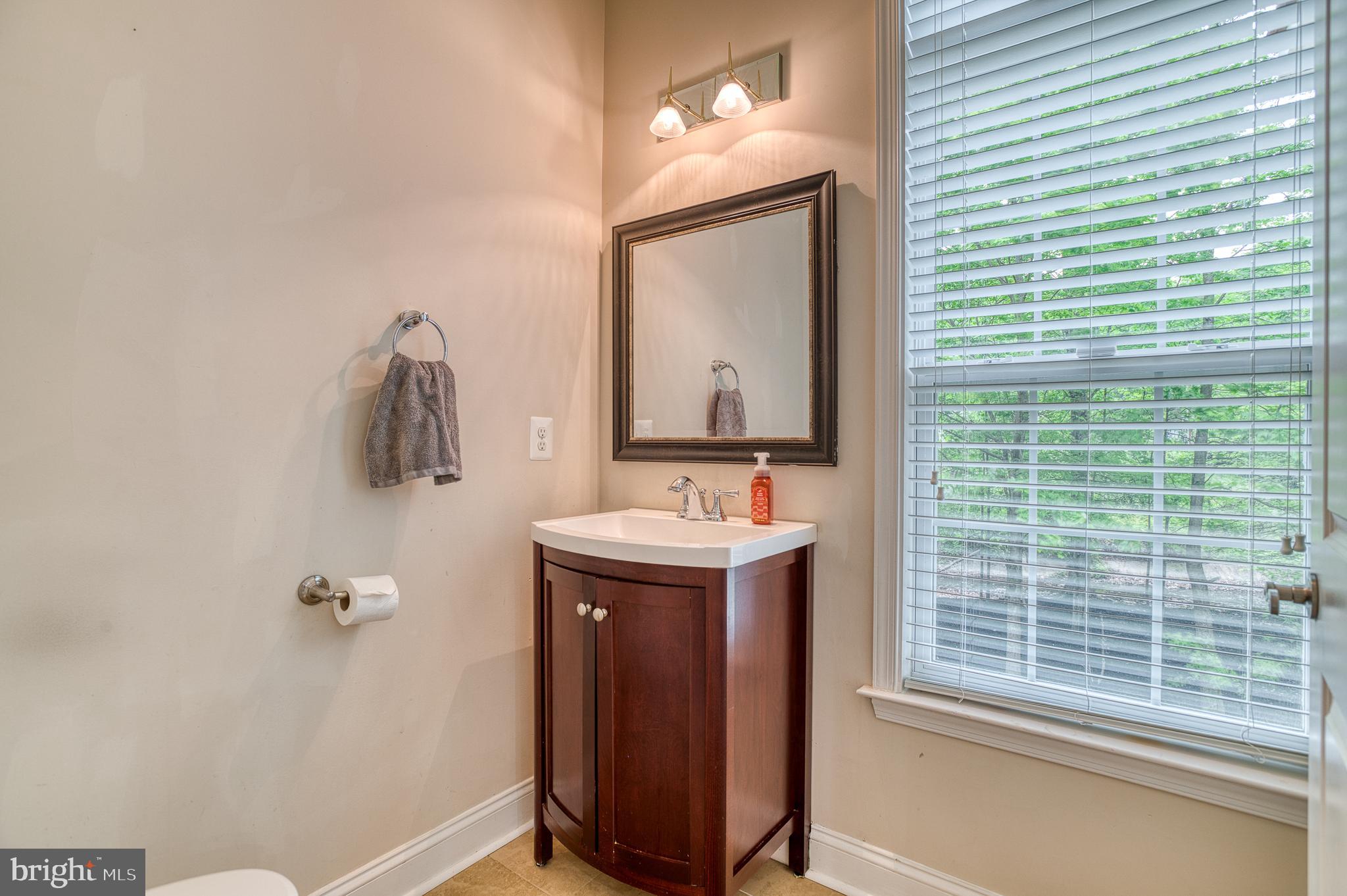 7140 Barry Road Alexandria, VA 22315 - Photo 9 of 56 a bathroom with a sink a mirror and a window