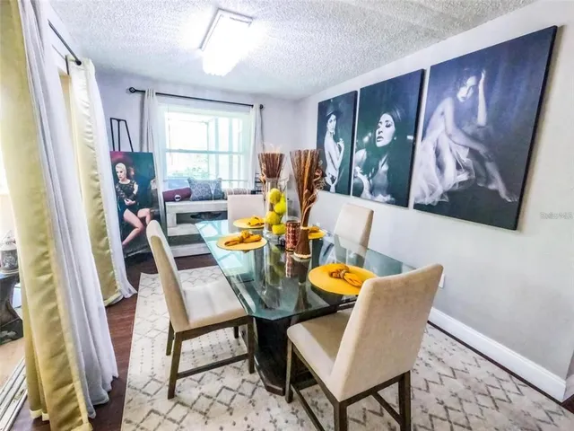 a view of a dining room with furniture a rug and wooden floor