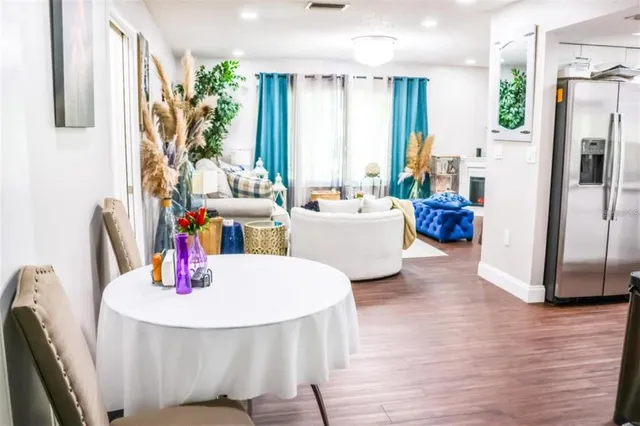 a view of a dining room with furniture a kitchen and chandelier