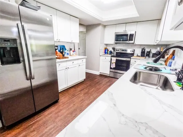 a kitchen with kitchen island white cabinets appliances and sink