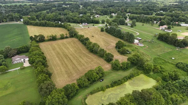 an aerial view of residential houses with outdoor space and trees