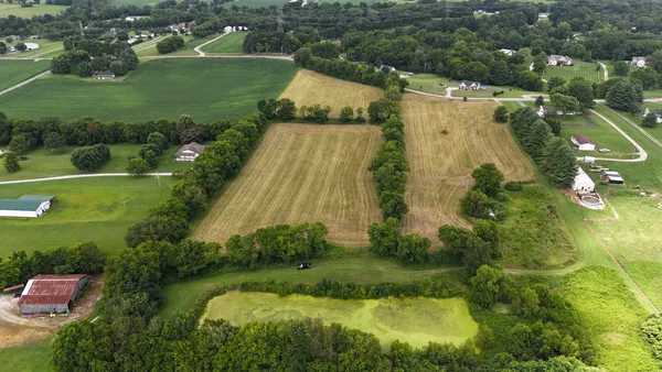 an aerial view of residential houses with outdoor space and trees