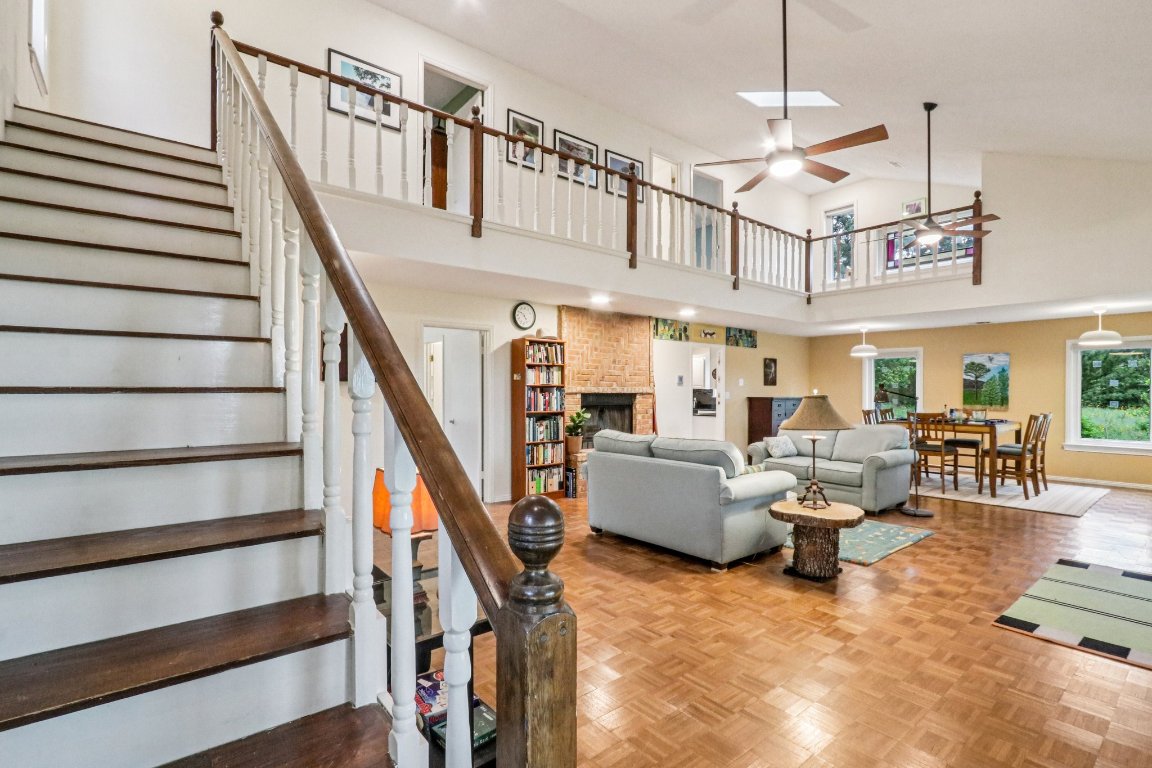 428 Gotier Trace Road Smithville, TX 78957 - Photo 9 of 40 Living area featuring ceiling fan, stairway, a brick fireplace, and high vaulted ceiling