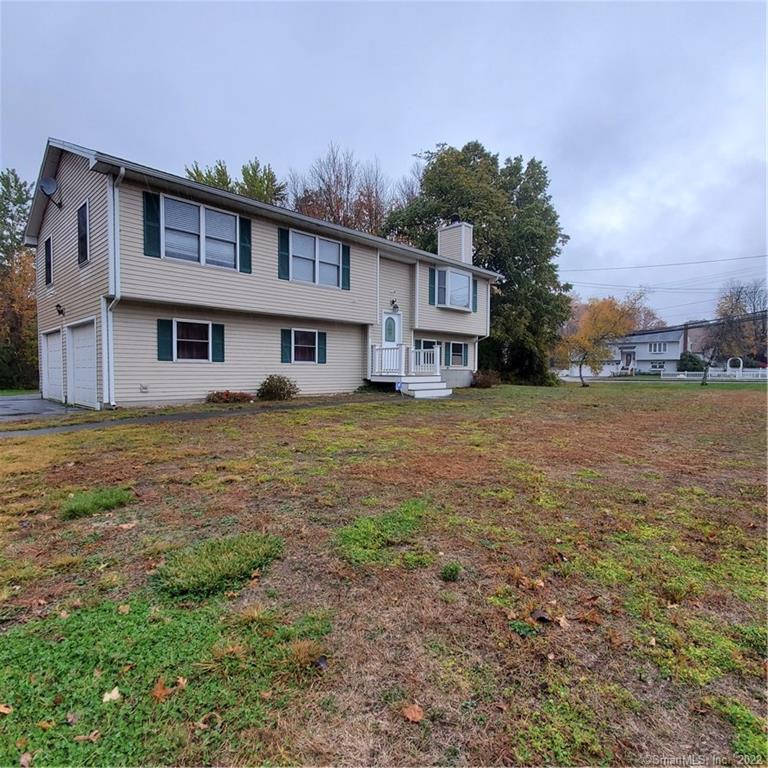 a view of a house with a big yard and large trees