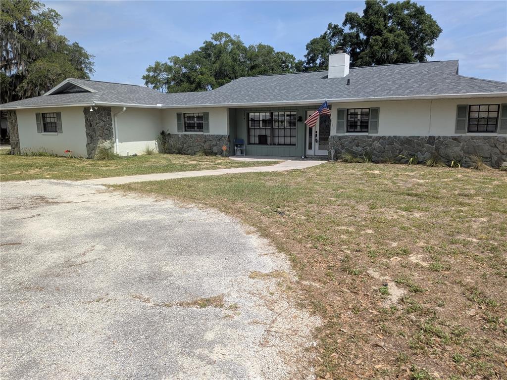 8801 East Cresco Lane Inverness, FL 34450 - Photo 2 of 51 a front view of house with yard and trees in the background